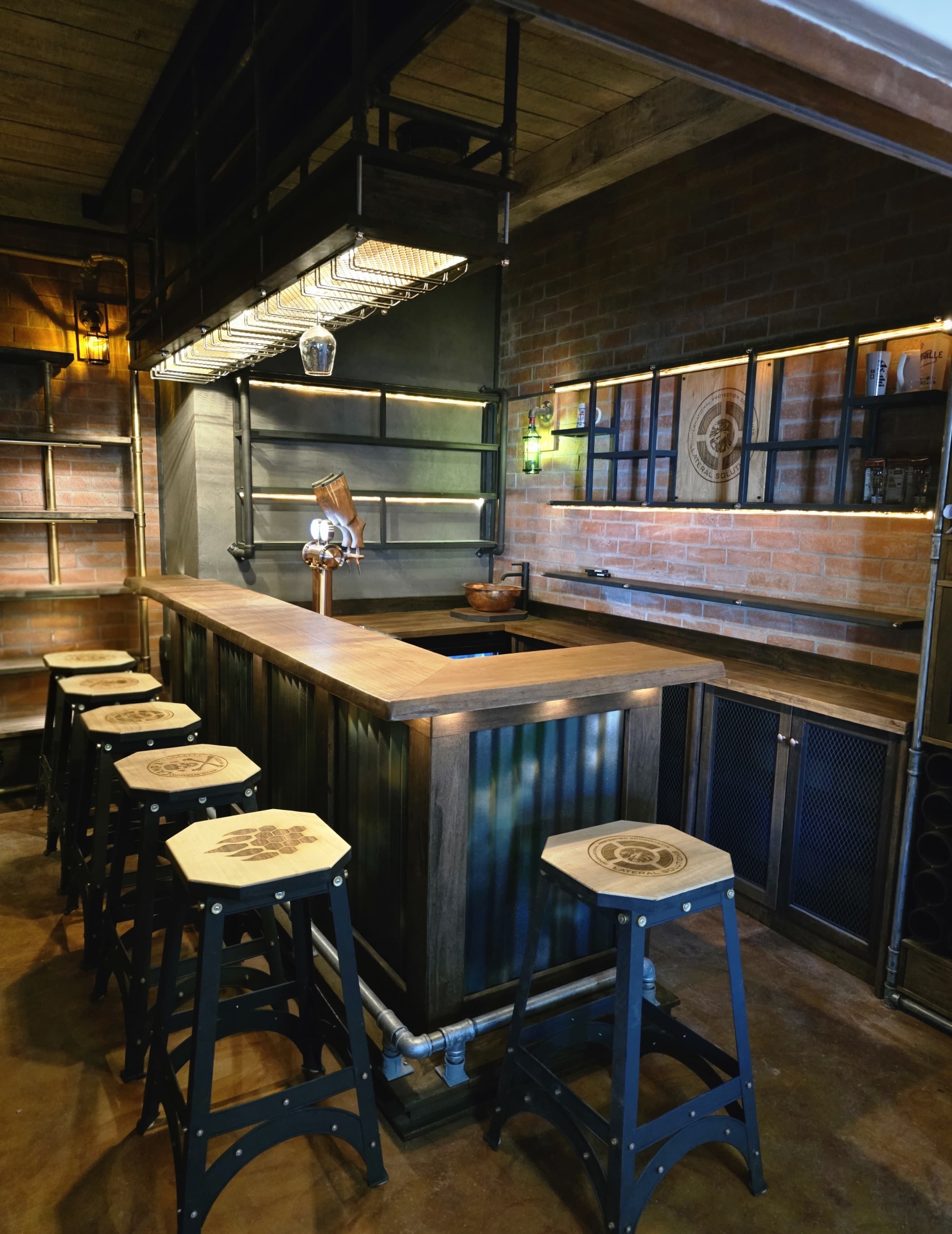 Military and steampunk themed home bar with corrugated steel cladding, timber bar top and industrial glass racks, built by Brandt Möbel Kreatif
